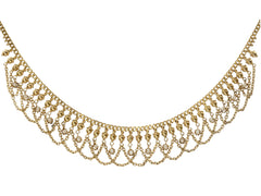 thumbnail of Detail view of a c1900 Edwardian chain collar with tiny seed pearl pendants and chain swags. Built in 14K yellow gold. Shown on white background.
