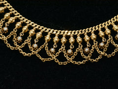 thumbnail of Close up view of a yellow gold c1900 Edwardian chain collar with tiny seed pearl pendants and chain swags shown dark background.