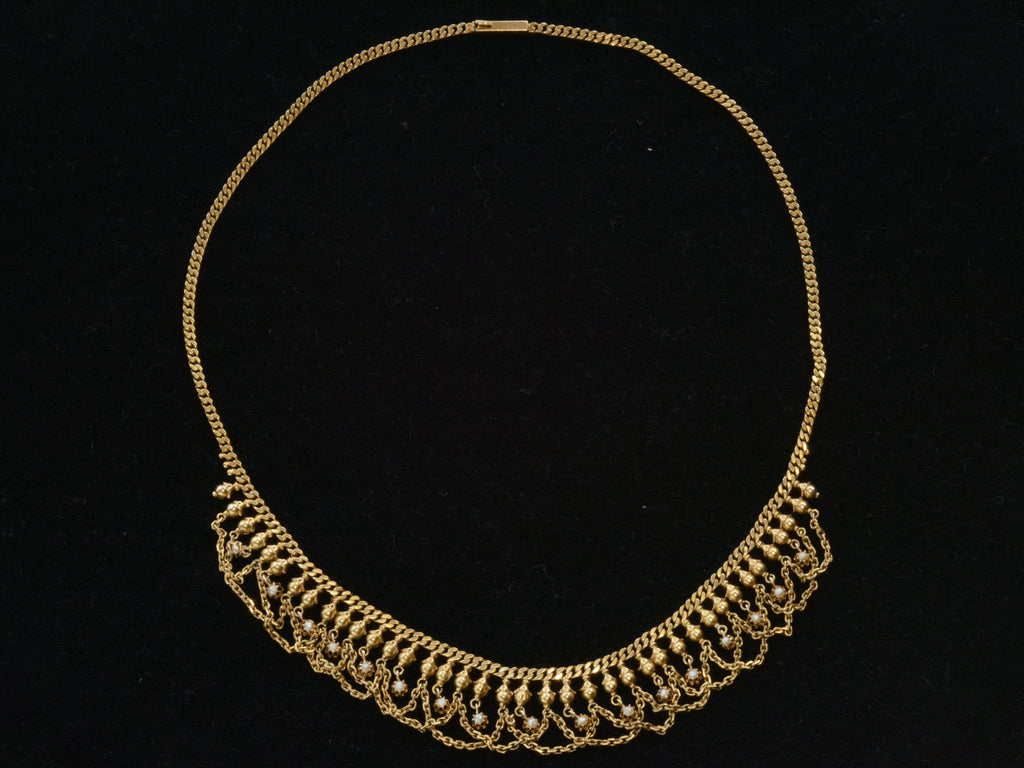 Full view of a yellow gold c1900 Edwardian chain collar with tiny seed pearl pendants and chain swags shown on black background.