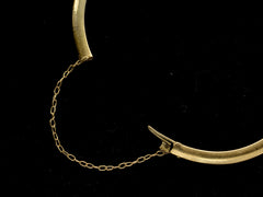 thumbnail of Detail view of bracelet's tongue clasp and safety chain, shown on dark background.