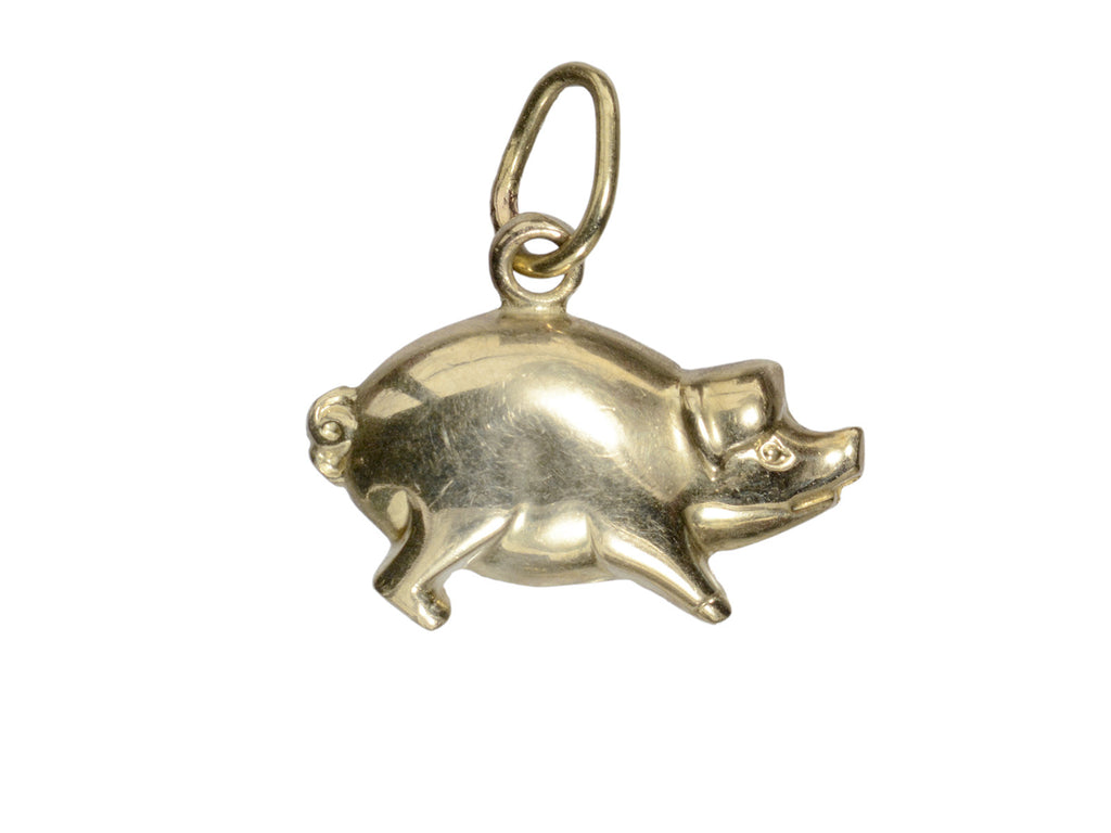 Gold pig charm on a white background, facing right