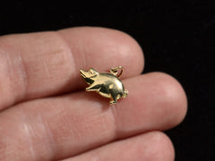 thumbnail of Gold pig charm held in hand