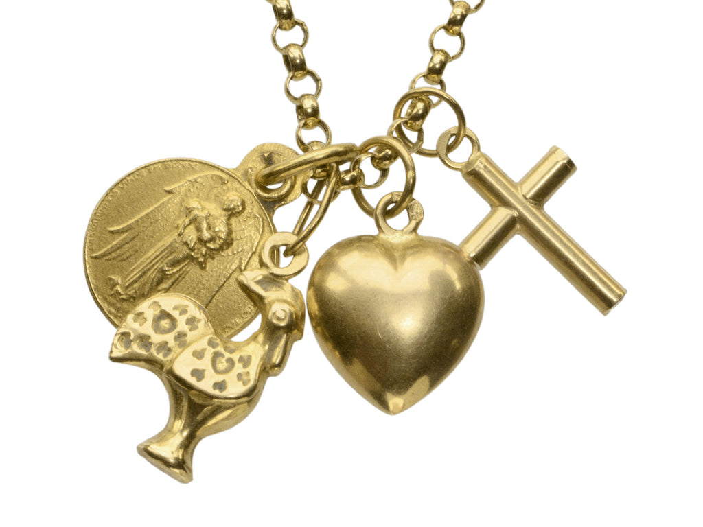 Detail of vintage 19k yellow gold Portuguese charm necklace with four charms: a devotional medallion of Christ, a rooster, a heart, and a cross. Shown on white background. 
