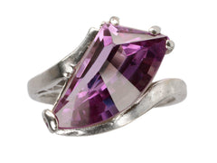 thumbnail of A white gold ring with wing shaped faceted purple stone, on white background.