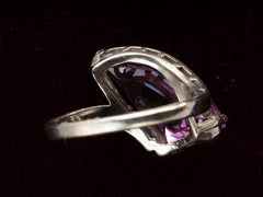 thumbnail of Inside view of white gold ring with wing shaped faceted purple stone, on black background.