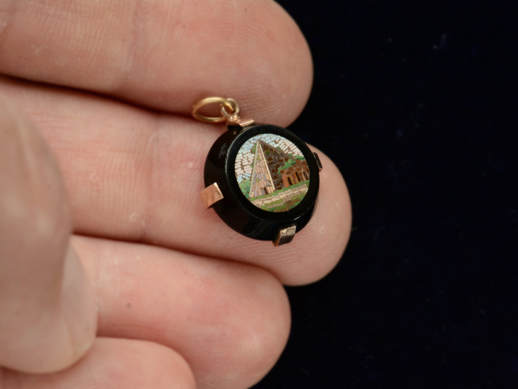 c1870 Black and Gold Round Pendant with a Micromosaic Image of a Pyramid (shown on hand for scale)