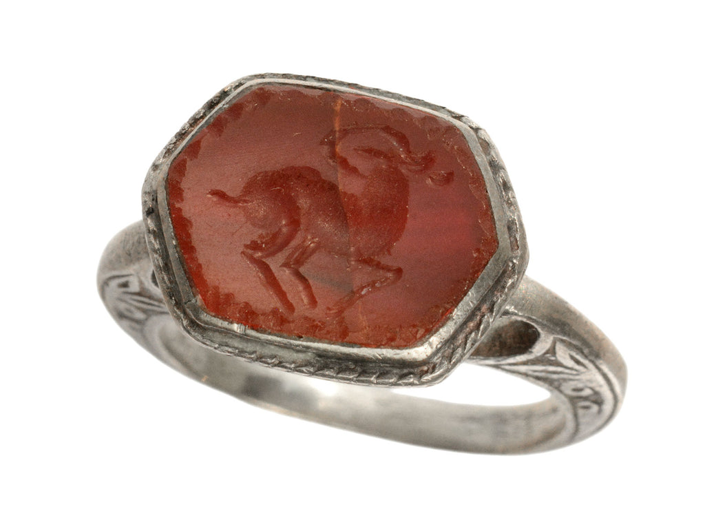 Angled front view of silver 19th century Persian carnelian intaglio ring with carved ram motif.  (shown on white background)