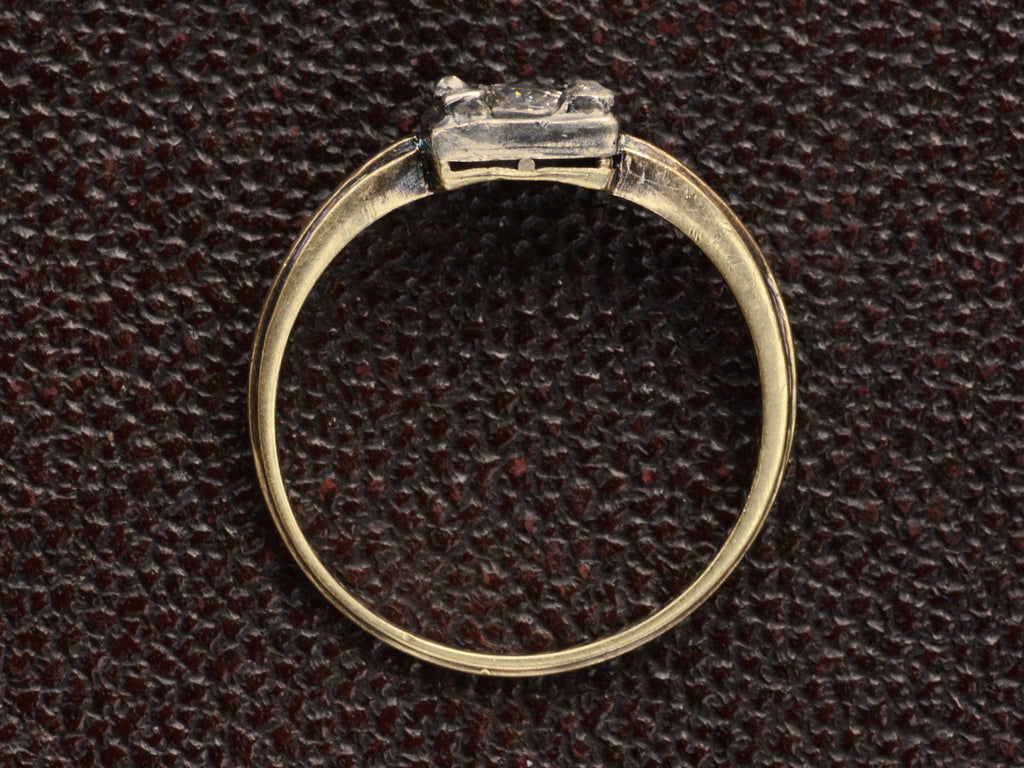 Side profile of antique silver-topped yellow gold ring shown on dark textured background.