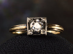 thumbnail of Front of silver-topped yellow gold ring with round diamond set on four prongs topped with tiny rose cut diamonds, shown on dark background.