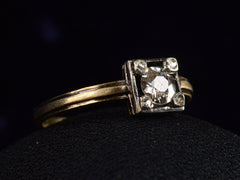 thumbnail of Side view of silver-topped yellow gold ring with round diamond set on four prongs topped with tiny rose cut diamonds, shown on dark background.