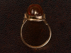 thumbnail of Side profile view of vintage ring with an oval amber cabochon in 14k rose gold, shown on dark textured background.