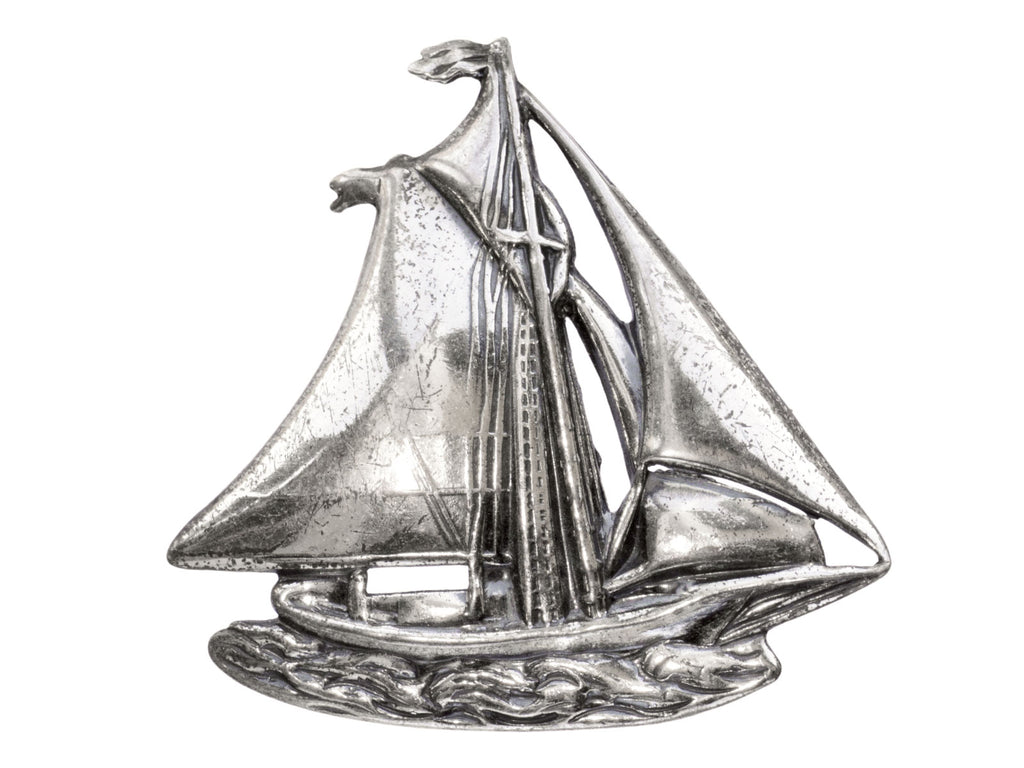 Vintage silver sailboat brooch on white background.