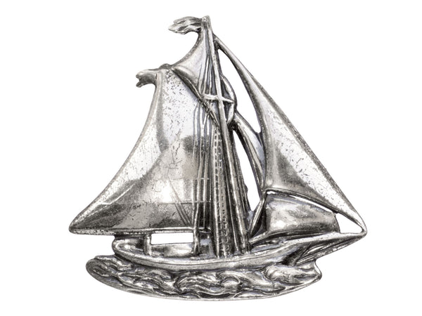 Vintage silver sailboat brooch on white background.