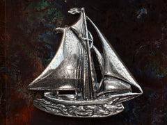 thumbnail of Vintage silver sailboat brooch on dark background.
