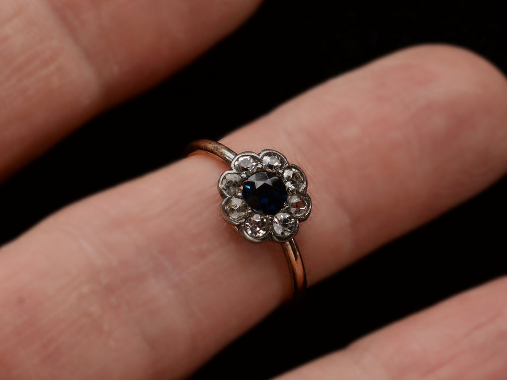 Antique silver topped gold ring with blue and white sapphires (shown on finger)
