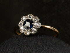 thumbnail of Angled view of antique silver topped gold ring with blue and white sapphires (shown on dark background)