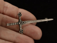 thumbnail of A Scottish silver sword pin, shown held in hand