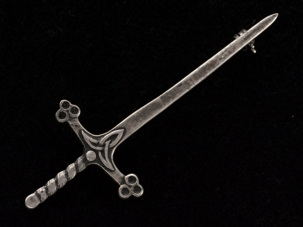 A Scottish silver sword pin, shown on black background