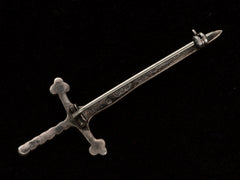thumbnail of Revese side of  Scottish silver sword pin, shown on black background. Scottish hallmarks are visible but not legible