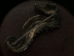 thumbnail of Reverse side view of c1970 Darkened Silver Seahorse Brooch on dark textured background.