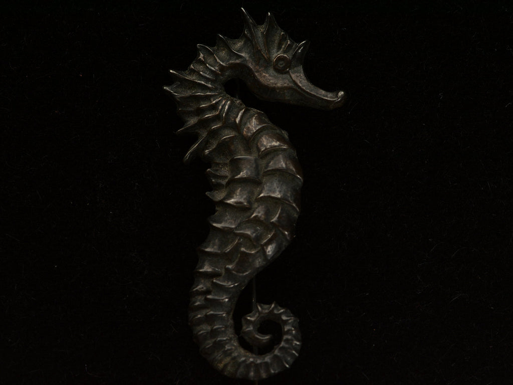 Ac1970 Darkened Silver Seahorse Brooch on dark background.