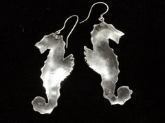 thumbnail of Reverse sides of a pair of vintage silver seahorse earrings, on black background.