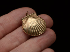 thumbnail of Reverse side of an antique Victorian scallop shell locket in gold, held on hand