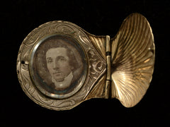 thumbnail of An antique Victorian scallop shell locket in gold, shown open with portrait of man inside, on black background
