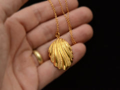 thumbnail of Victorian shell pendant necklace with detailed gold work, shown on hand for scale.