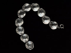 thumbnail of Reverse side of silver bracelet with scallop shell links, on black background.