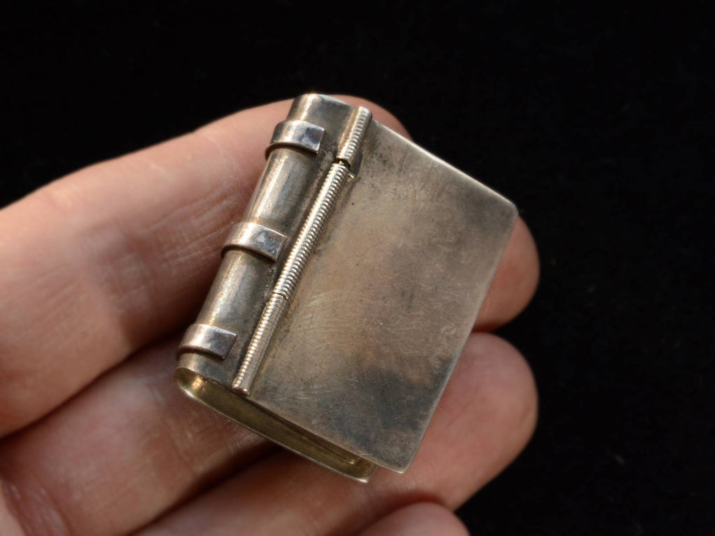 Angled view of c1970 Silver Book Box (shown closed on hand for scale)