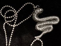 thumbnail of c1980 Silver Snake Necklace (reverse side on black background)