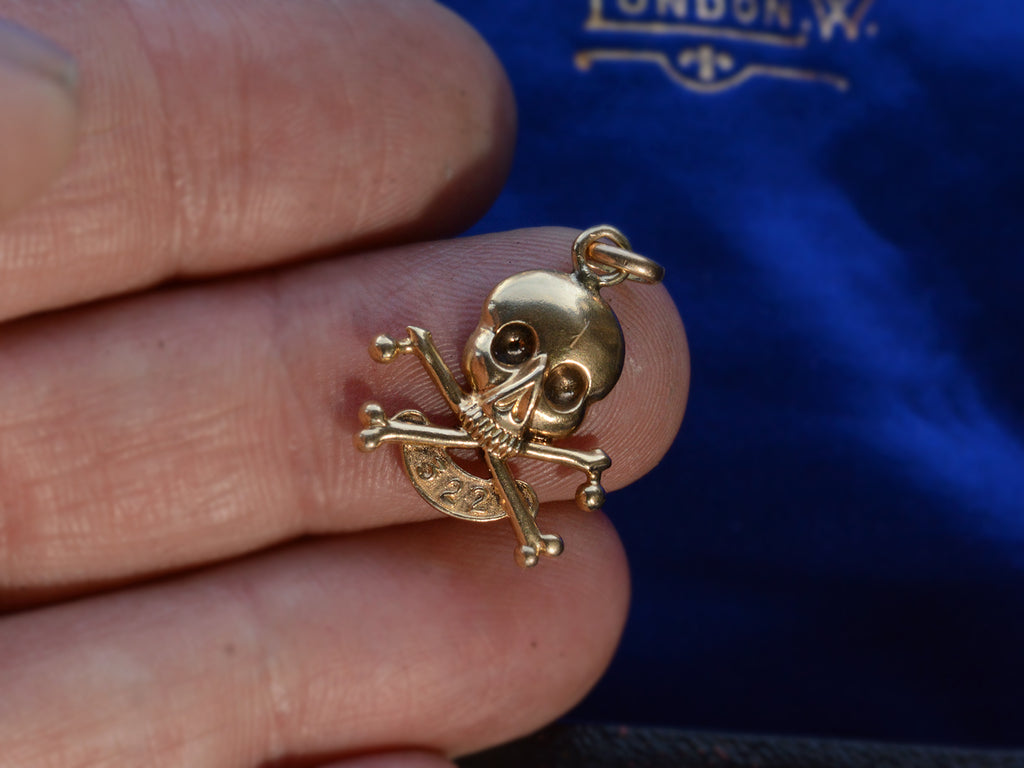 c1920 Skull & Bones Charm with the number 322 (shown on hand for scale)