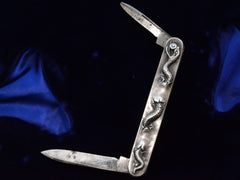 thumbnail of c1910 Silver Snake Knife (shown with 2 blades open on dark blue background)