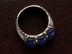 thumbnail of The side profile of a silver ring featuring three polished dark blue resin stones, shown against dark textured background