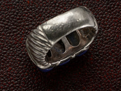 thumbnail of The inside of a silver ring featuring three polished dark blue resin stones, shown against dark textured background