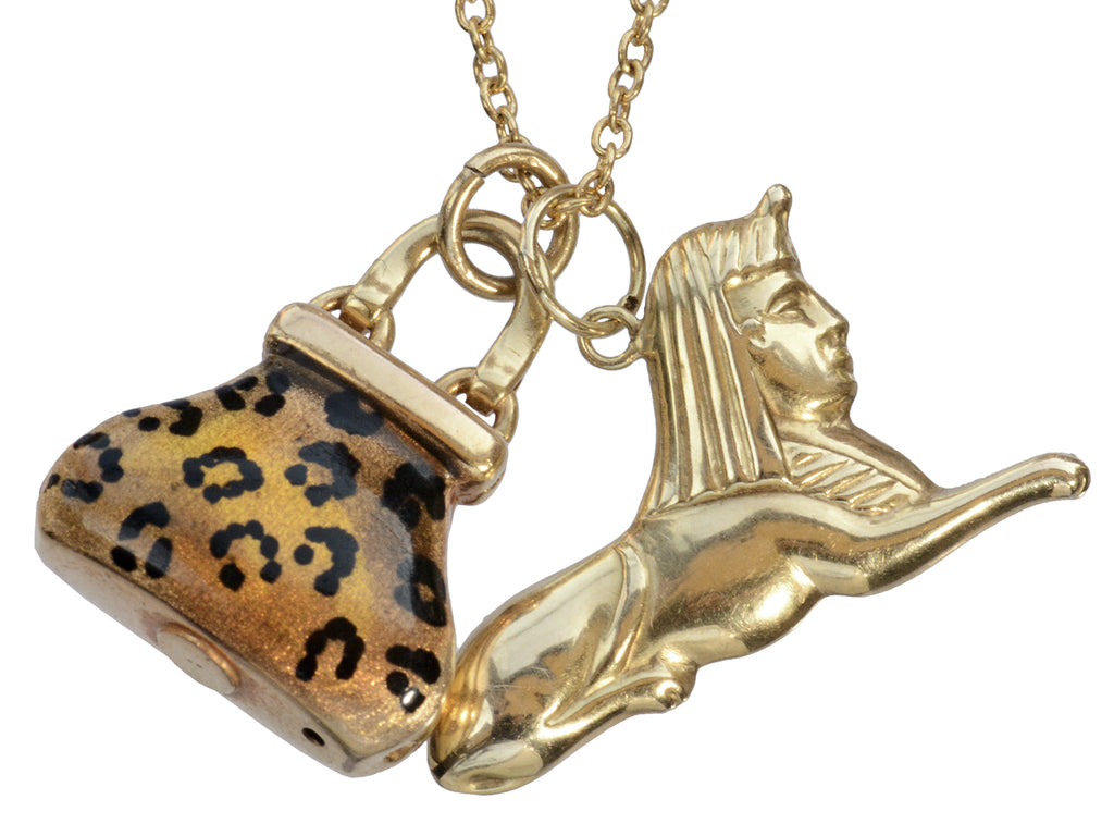 Detail of c1970 Sphinx & Purse Charms in yellow gold with cheetah print enamel. Shown on white background.