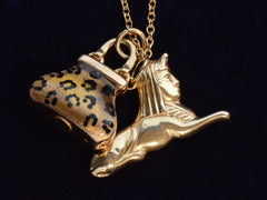 thumbnail of Detail of c1970 Sphinx & Purse Charms in yellow gold with cheetah print enamel. Shown on black background.