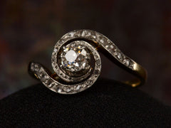 thumbnail of Angled view of antique Art Nouveau spiral form with diamonds in platinum-topped gold, shown on dark background.