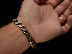 thumbnail of A vintage Italian sterling silver chain bracelet with beveled curb links draped over wrist.