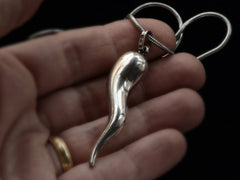thumbnail of Detail of a vintage Italian silver necklace with a large cornicello horn pendant, shown on held in hand