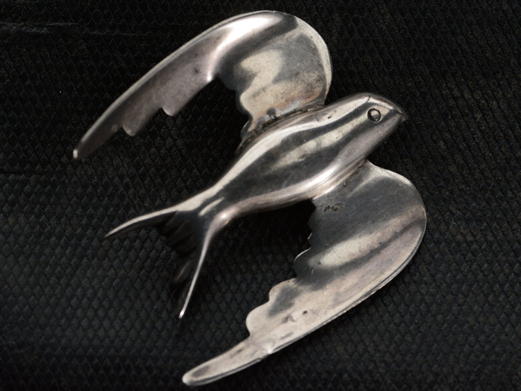 A c1950 Silver Dove Brooch on dark textured background