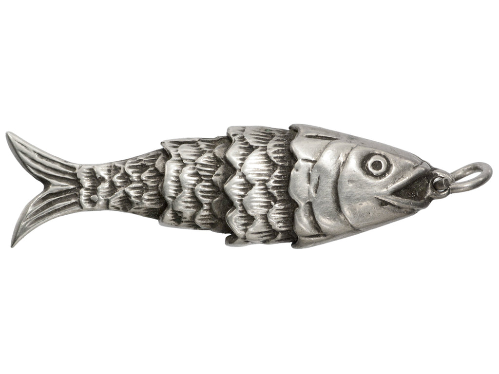 A silver fish-shaped pendant or charm with detailed scales, an eye, and a small loop at the top, shown on a plain white background.