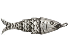 thumbnail of A silver fish-shaped pendant or charm with detailed scales, an eye, and a small loop at the top, shown on a plain white background.