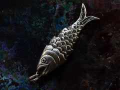 thumbnail of A down- facing sterling silver articulated fish pendant on dark iridescent background. "SILVER" stamp visible on tale.