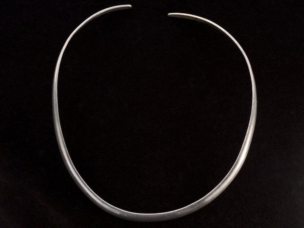 A simple silver neck cuff shown on black background.