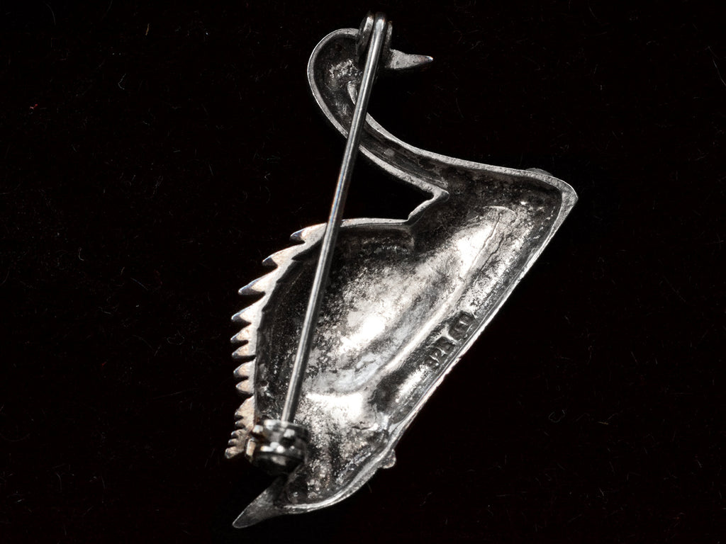 Reverse side of a sterling silver swan brooch on black background. A stamp on the back reads "925" with a second illegible mark.