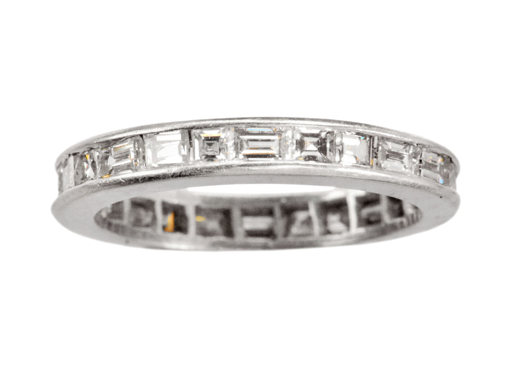 A platinum eternity band set with square and rectangular diamonds, shown on white background.