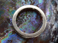 thumbnail of Side profile of a platinum eternity band set with square and rectangular diamonds, shown on dark colorful background.