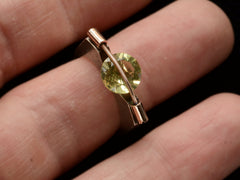 thumbnail of Plodowski ring with a green stone tension set with yellow gold against a silver mounting, shown on finger